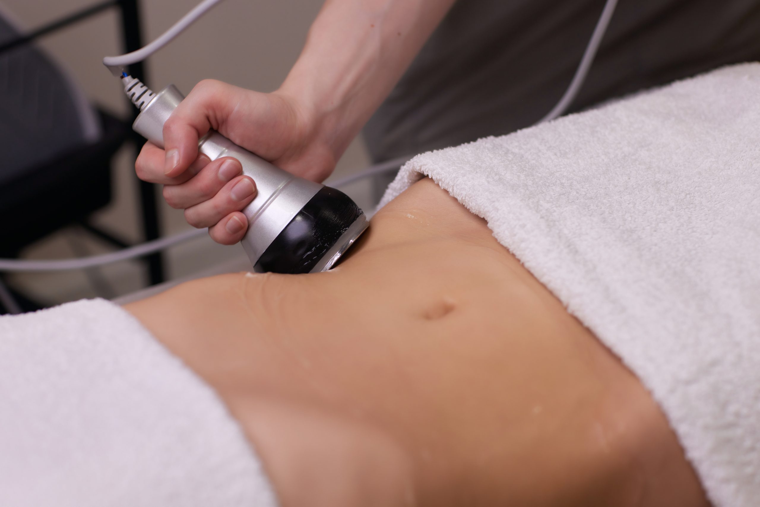 procedure removing cellulite on female abdomen, cavitation belly massage. ultrasonic massage for weight loss. correction of female figure without surgical intervention. closeup of the tummy.