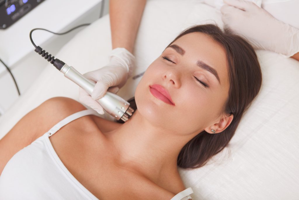attractive young woman getting facial cosmetoogy treatment