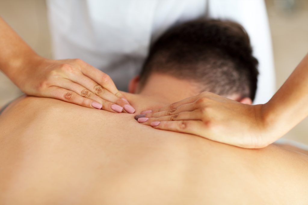 handsome man having massage in spa salon