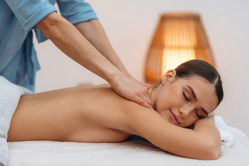 spine massage. relaxed young woman is with therapist in spa salon